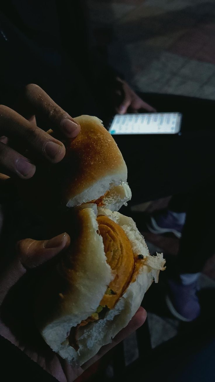 a person holding a sandwich in their hands