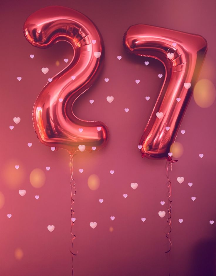 the number twenty two balloons are hanging in the shape of heart - shaped balloons on a pink background