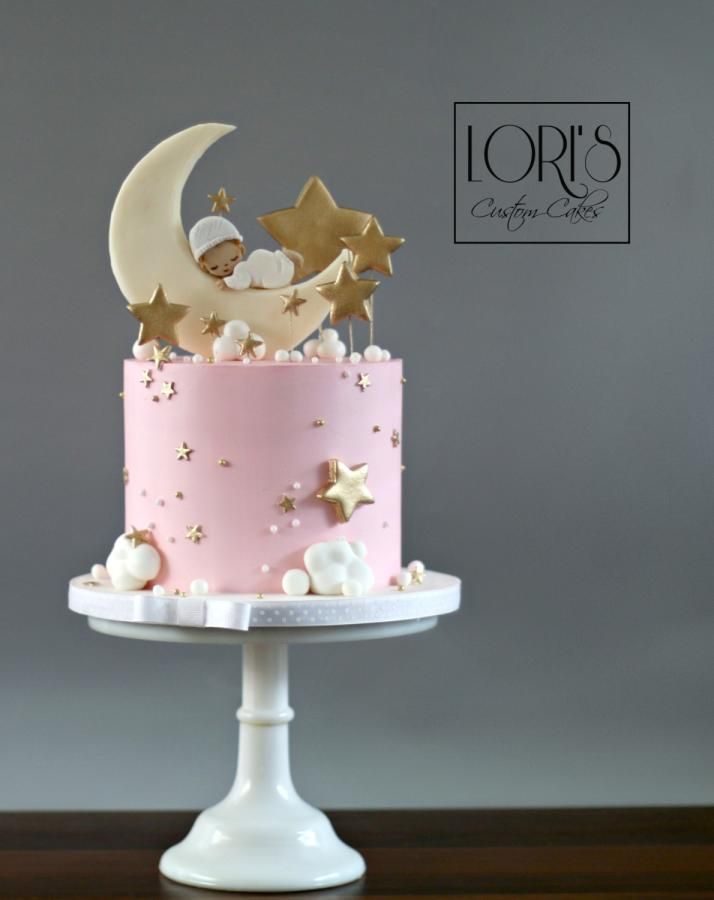 a pink cake with gold stars and moon decorations