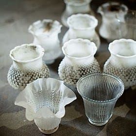 several glass vases sitting on top of a table next to each other in different shapes and sizes