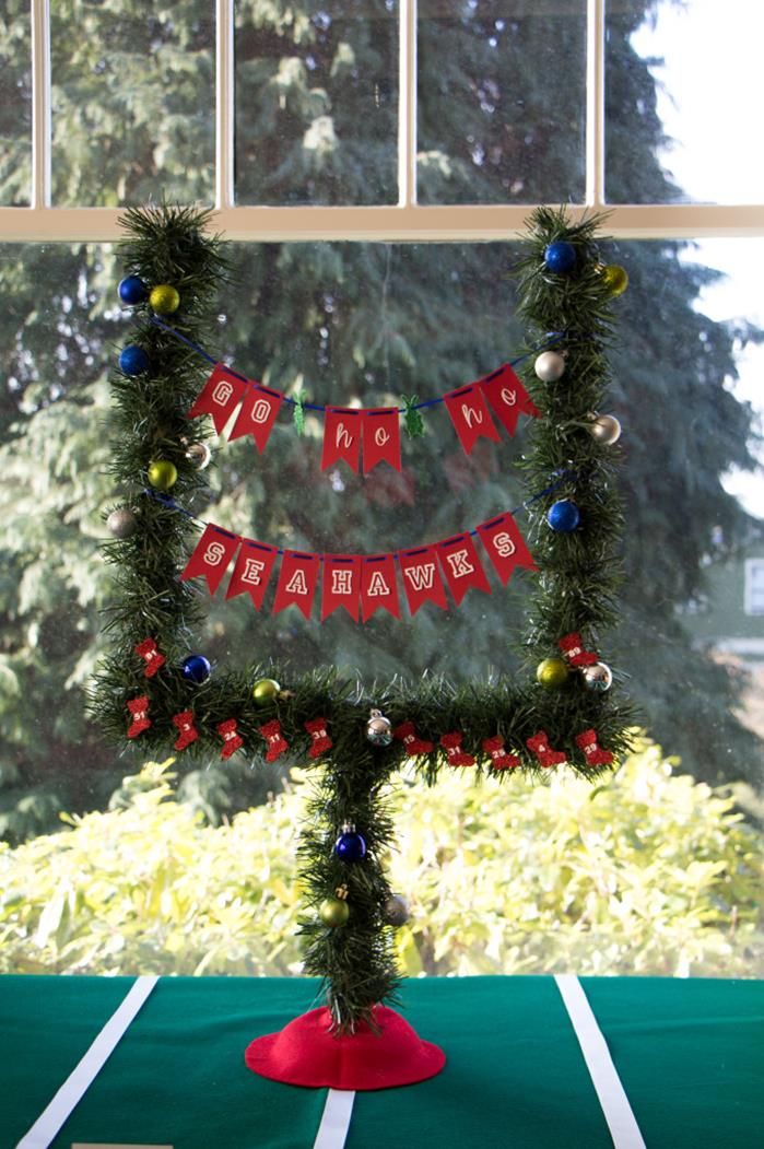 a christmas decoration made out of fake garland and ornaments on a table in front of a window