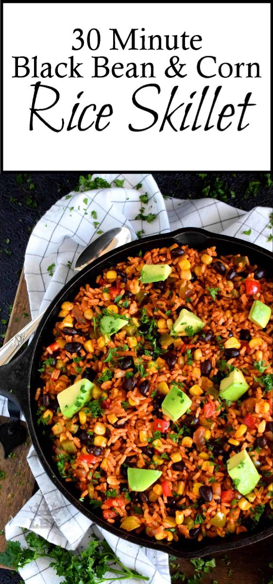 a skillet filled with rice, beans and avocado on top of a table