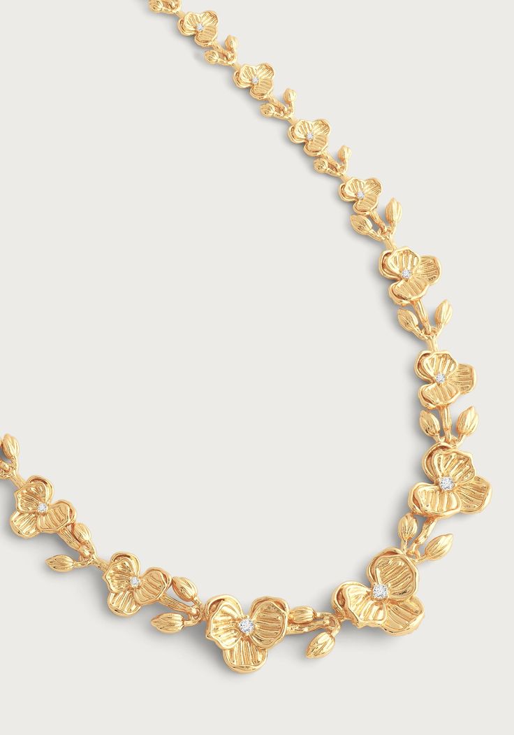 Crafted from 18k gold dipped brass, accented with hand set crystal. The sculpts of the necklace are thoughtful and lightweight, making this extraordinary piece as stunning as it is comfortable to wear. Experience effortless elegance with our Orchid Link Necklace. The handcrafted 18k gold dipped brass and hand set crystal accents create a stunningly lightweight piece that will elevate any outfit. Indulge in luxury and comfort with every wear. 18K Gold Plated Brass Crystal 20" L Delicate Gold Plated Jewelry, Fine Jewelry Gold Brass Necklace, Gold Brass Necklace Fine Jewelry, Gold-tone Plated Wedding Necklace, Gold Jewels Design Set, Dainty Yellow Gold Plated Necklace, Luxury Hand Forged Brass Necklaces, Gold-tone Necklace With Plating As A Gift, Gold-tone Plated Necklaces As Gift