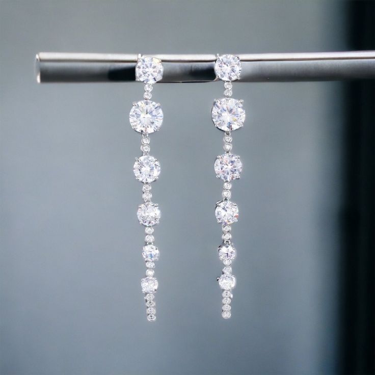 Style: Cubic Zirconia Dangle Rhinestone Bridal Earrings Color: Clear CZ Rhinestones on Silver Length: 3.14" Dangle Rhinestone Bridal Earrings As Gift, Dangle Bridal Earrings With Rhinestones, Bridal Dangle Earrings With Diamonds And Rhinestones, Bridal Dangle Earrings With Rhinestones, Diamond Dangle Bridal Earrings With Rhinestones, Diamond Bridal Dangle Earrings With Rhinestones, Diamond White Rhinestone Drop Bridal Earrings, Diamond White Rhinestone Bridal Drop Earrings, Sparkling Crystal Dangle Diamond Earrings