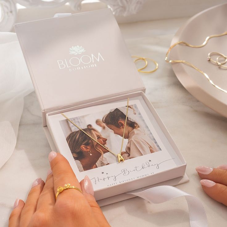 a woman's hand holding onto a ring in front of a box with a photo on it