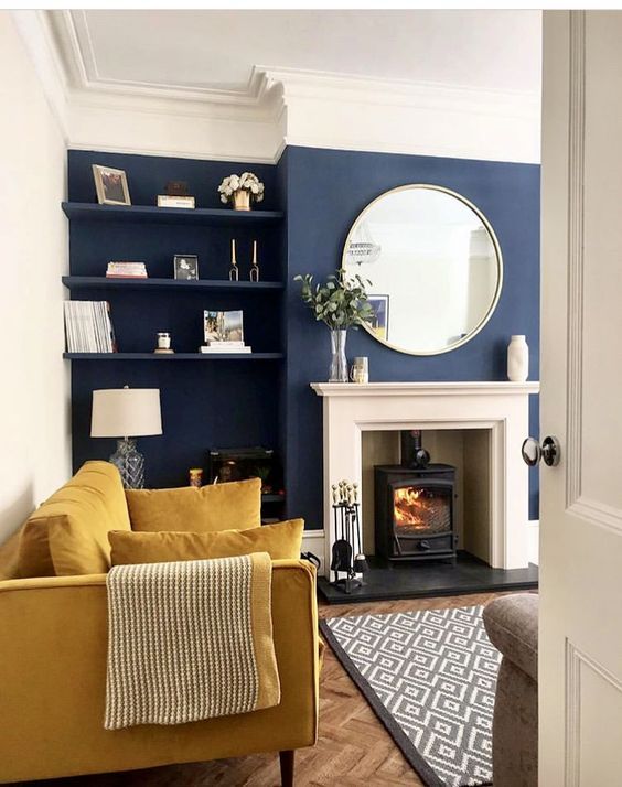 a living room filled with furniture and a fire place next to a mirror on the wall