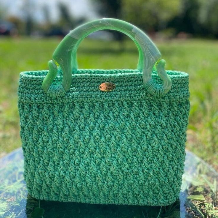 A green jewel that shines your style.With its ideal size,  "Esmeralda" provides ample space for your essentials, making it a safe choice for women seeking both style and functionality! Esmeralda is a crochet bag in green, featuring textured filaments that add a unique touch to its artisanal beauty.  Its resin handles are particularly distinctive, while the inner lining boasts a green patterned fabric that adds a lively flair. T he rigid green faux leather bottom provides structure to the bag. Me Green Handheld Crochet Bag For Summer, Green Handheld Crochet Bag For Beach, Green Beach Bag With Detachable Handle, Green Shoulder Bag With Detachable Handle For Beach, Handmade Green Rectangular Bag, Green Beach Bag With Top Carry Handle, Green Crochet Bag For Daily Use, Handmade Green Top Handle Shoulder Bag, Green Top Handle Beach Bag