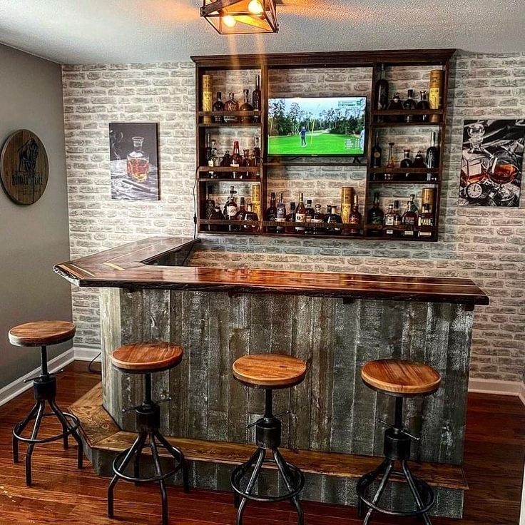 a bar with three stools in front of it and a television on the wall