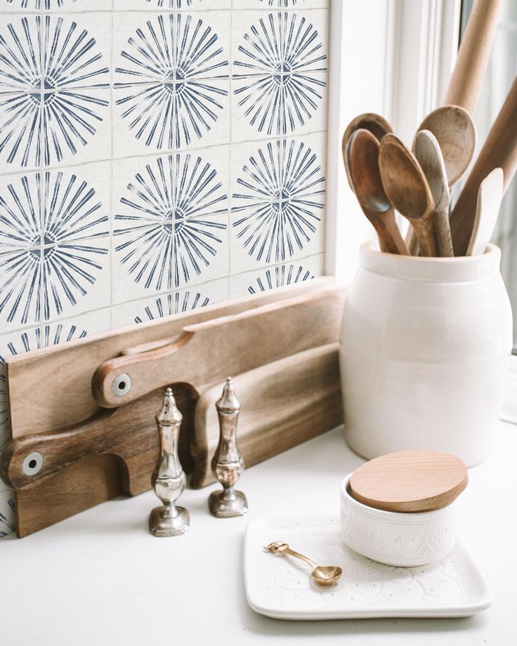 utensils and spoons are sitting in a white container on a kitchen counter