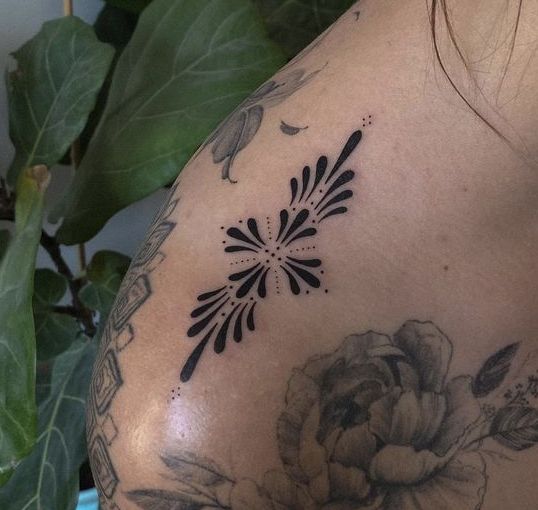 a close up of a woman's shoulder with flowers on it