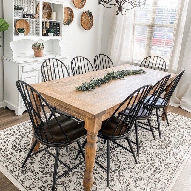 a dining room table with chairs and a rug