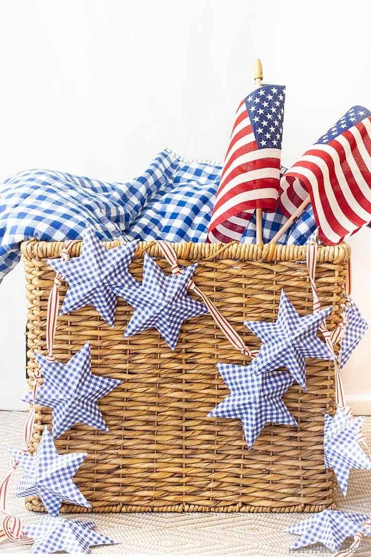 a basket filled with stars and flags on top of a wooden floor next to pillows