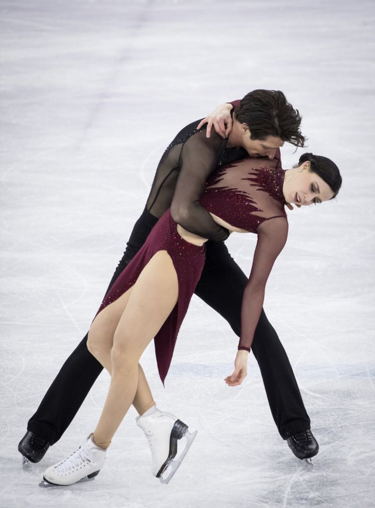 two people are skating on an ice rink