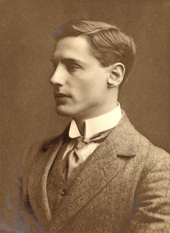 an old black and white photo of a man in a suit with a bow tie