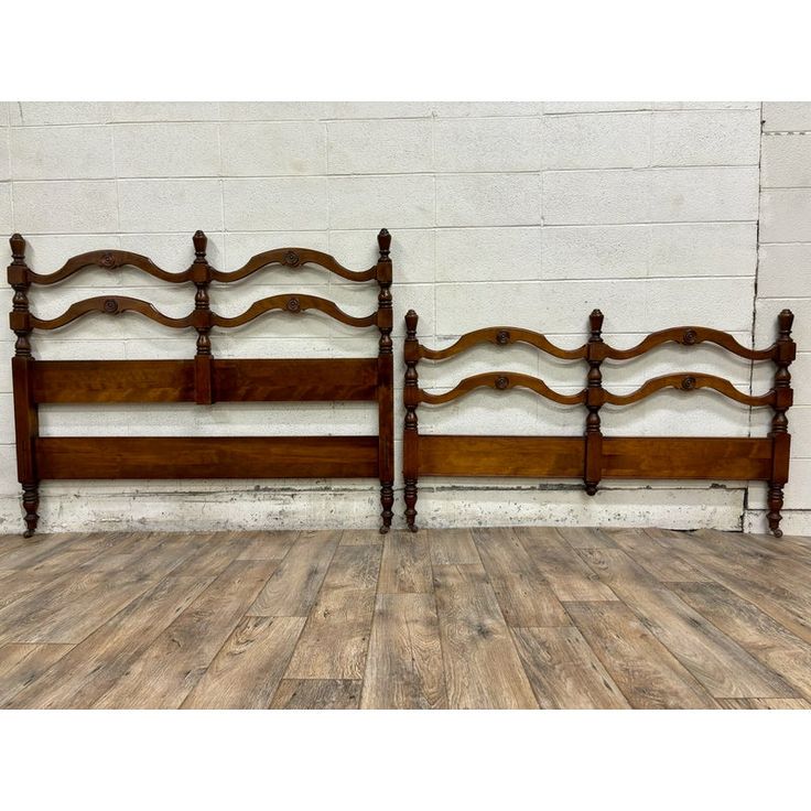 two wooden headboards sitting next to each other on top of a hard wood floor