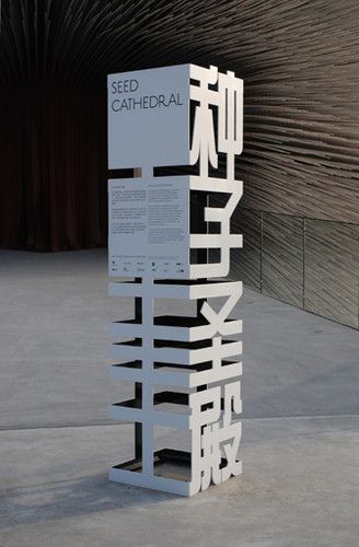 a tall white sign sitting on top of a cement floor