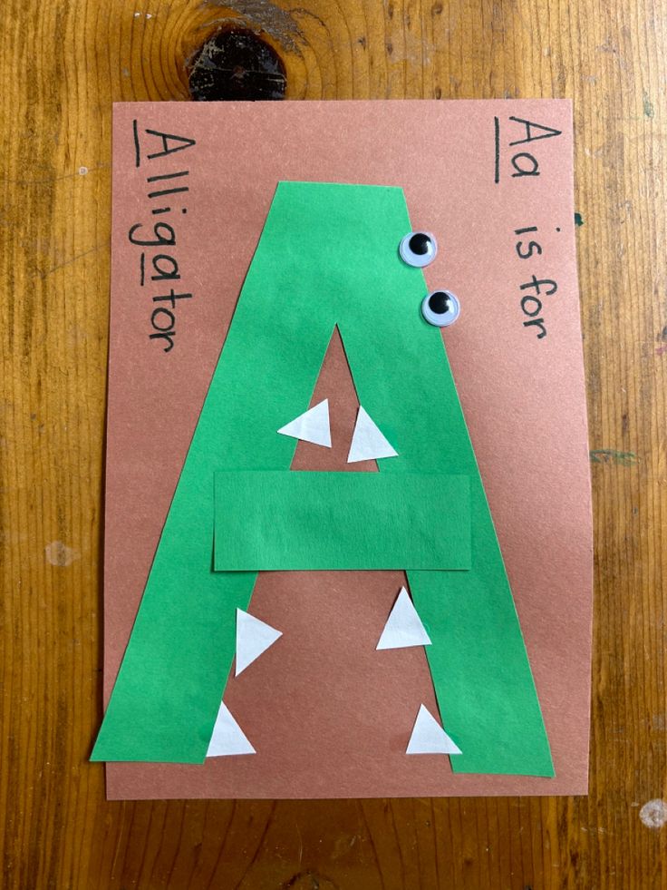 the letter a is made out of paper with googly eyes and an alligator's mouth