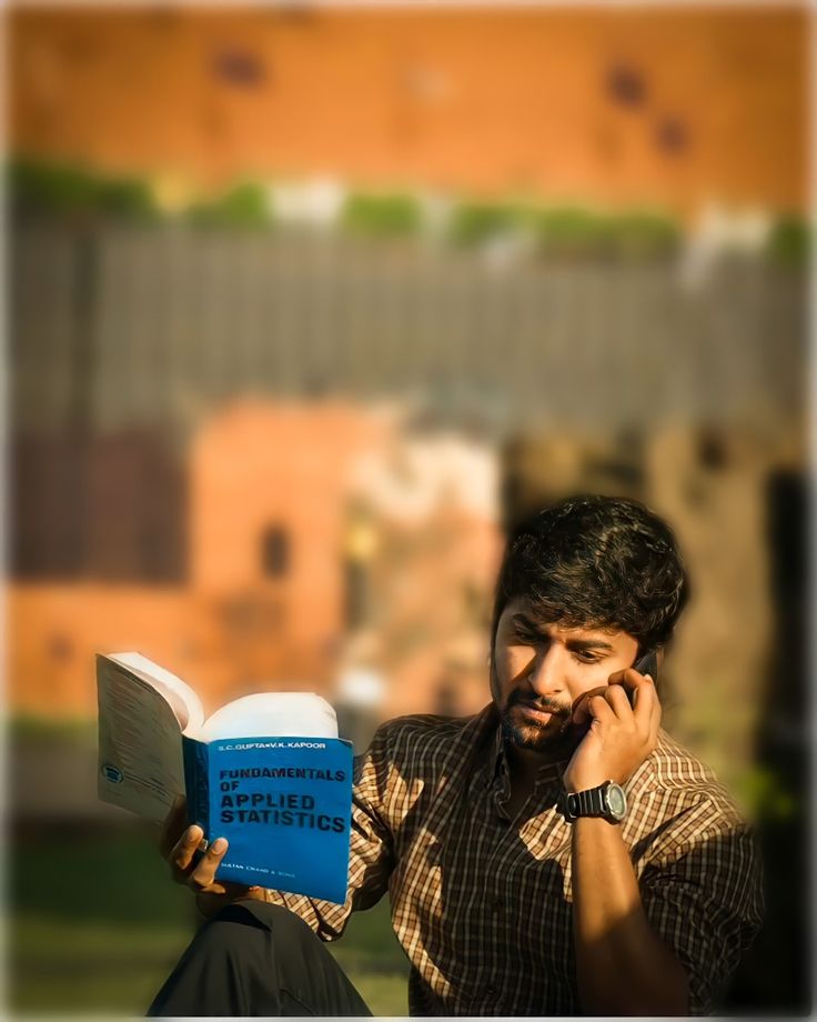 a man is talking on his cell phone while reading a book