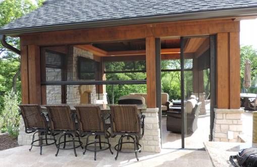 a patio with chairs and an outdoor kitchen