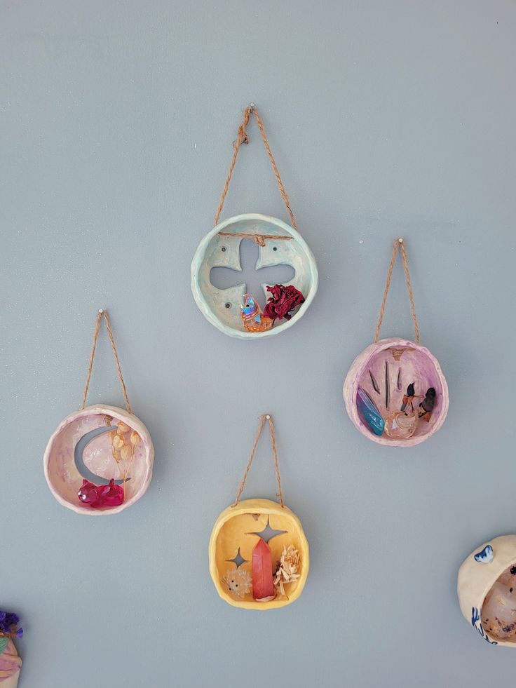 five hanging ornaments on a gray wall, each with an image of a child's birth