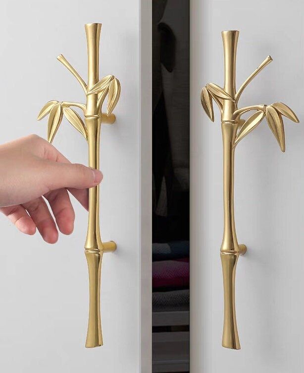 a person is holding onto the handle of a door with a gold palm tree design on it