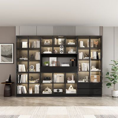 a living room filled with lots of bookshelves next to a wall mounted tv