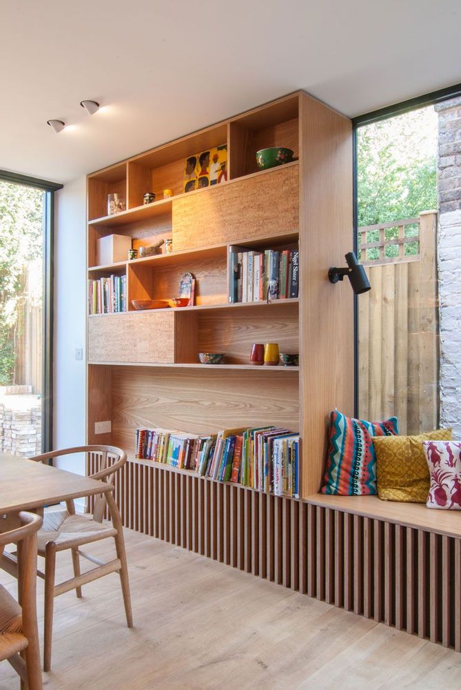 a wooden table sitting next to a book shelf filled with books