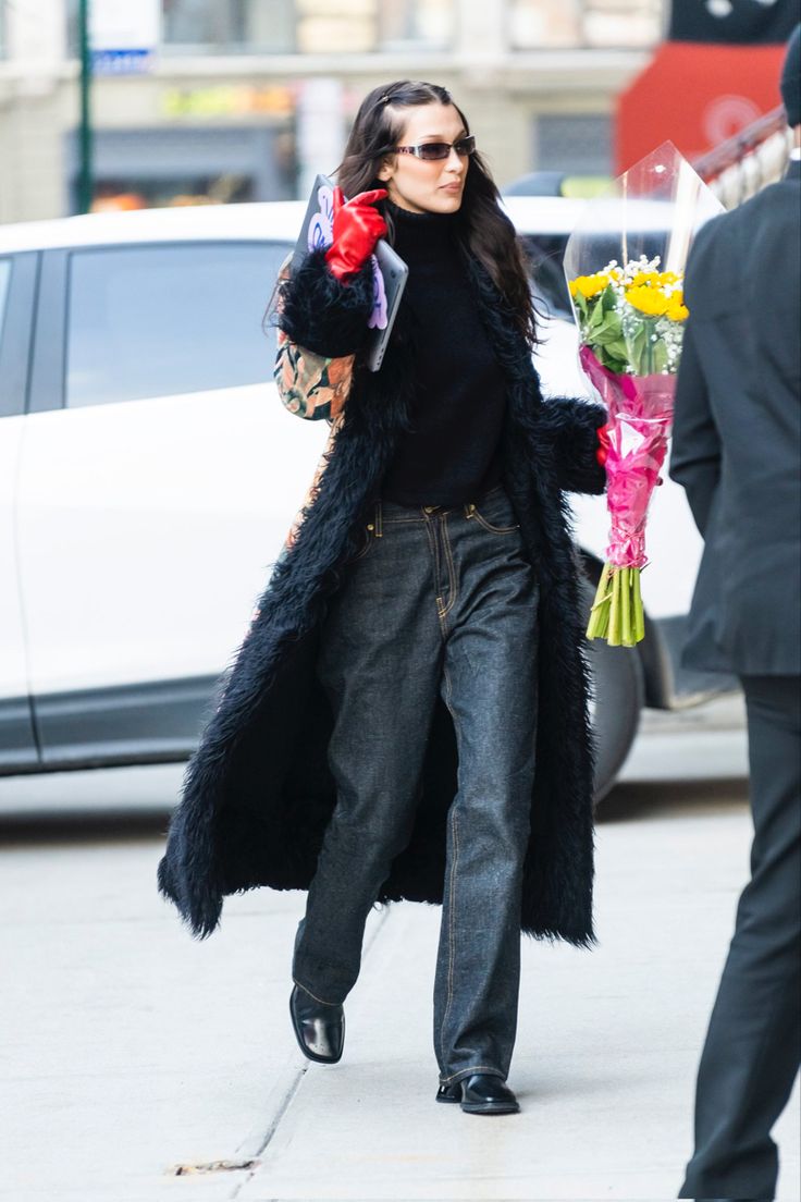 a woman is walking down the street with flowers