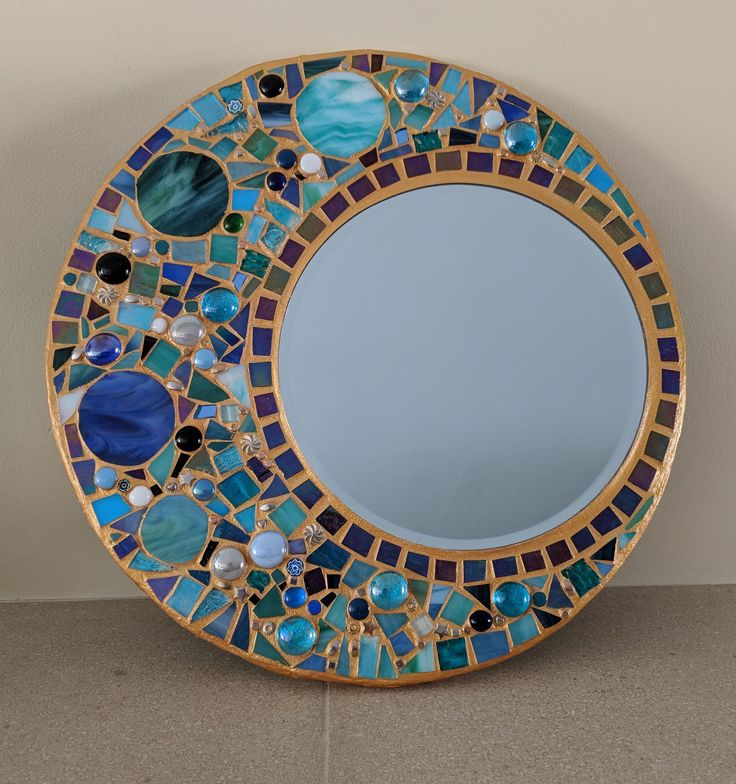 there is a blue and green mosaic mirror on the wall