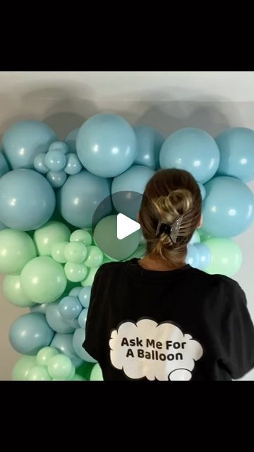 a woman is standing in front of balloons