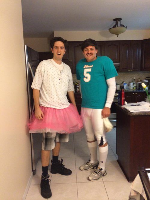 two young men standing next to each other in front of a kitchen counter and refrigerator