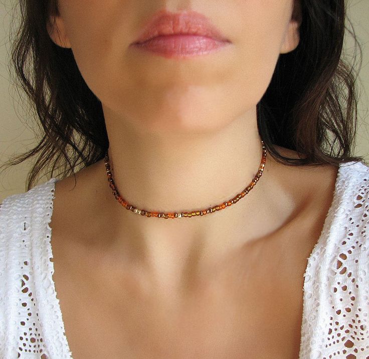 Beaded Choker Necklace Brown Choker Simple and elegant mixed copper, brown, gold and orange beaded choker with glass tiny seed beads. Perfect for wearing with other chokers or alone! DESCRIPTION Made from 2mm glass seed beads and closes with a gold plated clasp and 2 inches adjustable chain. SIZE Necklace is 13 inches and can be adjusted up to 15 inches with a 2 inches extender chain. Please let me know if you would like a different length. WRAPPING - All ZafireniaDainty jewelry arrive gift wrap Summer Brown Round Beads Jewelry, Beaded Brown Choker As Gift, Brown Beaded Choker As Gift, Brown Choker, Choker Simple, Gold And Orange, Colorful Necklace, Copper Brown, Gold Choker