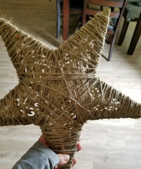 a person holding up a star made out of twine