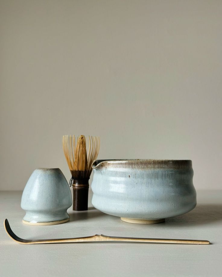 a white bowl with a wooden handle next to it