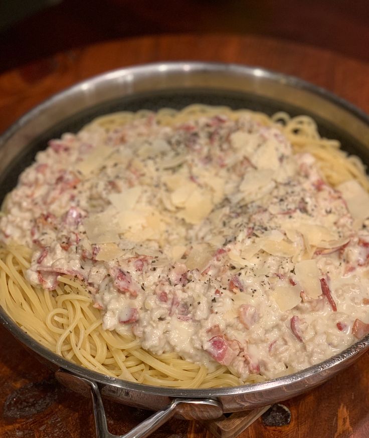 a pan filled with pasta and cheese on top of a wooden table