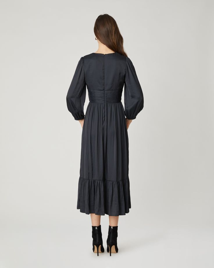 Gorgeous black satin midi dress. This style features a v-neckline with a fitted bodice, decorative buttons at the center front, shirring at the shoulder and waistband, ¾ length balloon sleeves with encased elastic at the openings, and a shirred full midi skirt with bottom ruffle flounce. Bodice lined. Sleeves and skirt unlined. Hidden back zipper. 100% Polyester. Dry clean or hand wash. Color: Jet Elegant V-neck Dress With Smocked Bodice, Formal Midi Dress With Gathered Sleeves For Fall, Evening V-neck Midi Dress With Fitted Waist, Elegant Fall Midi Dress With Gathered Sleeves, Elegant Midi Dress With Gathered Sleeves For Fall, Elegant Formal Midi Dress With Smocked Bodice, Elegant Formal Dresses With Gathered Waist, Chic Empire Waist Midi Dress With Ruched Bodice, Chic Midi Dress With Ruched Bodice And Empire Waist