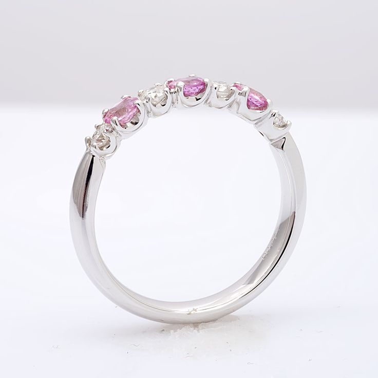 This half studded band has been set with pink sapphires and diamonds in calibrated sizes. 18k white gold holds each gem in a secure prong setting. The light pink tones are currently a trending color like the pastel colors of Rose Quartz. The perfect ring for your fashionista fiancé set with 0.57 carats of pink sapphires. Order online info@jupitergem.com Pink Ruby Ring In Platinum, Fine Jewelry Pink Sapphire Ring With Diamond Accents, Fine Jewelry Pink Diamond Ring In Platinum, Pink Sapphire Ring With Diamond Accents, Pink Half Eternity Diamond Ring, Pink Platinum Ruby Ring For Wedding, Classic Pink Half Eternity Jewelry, Pink Diamond Ruby Ring With Brilliant Cut, Pink Sapphire Ring In Platinum For Anniversary