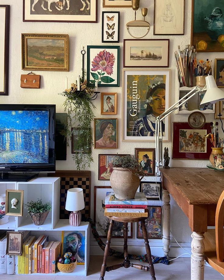 a living room filled with lots of pictures on the wall and a tv sitting on top of a wooden table