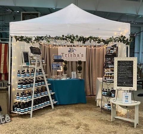 the tent is set up for an event with wine bottles on display and lights strung from the ceiling