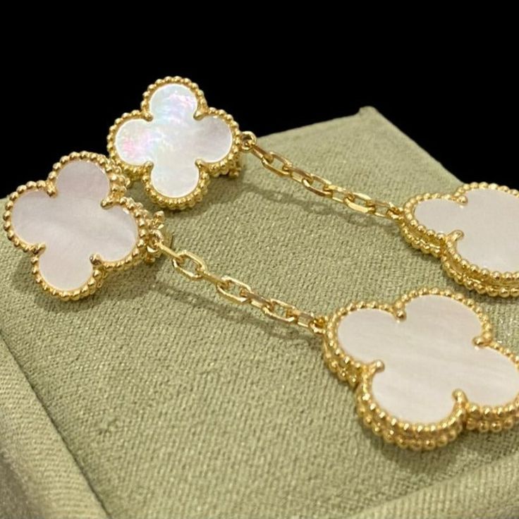 Discover the elegance of these Clover White MOP Earrings. Featuring two intricate motifs, these earrings are expertly crafted to add a touch of sophistication to any outfit. Made with premium materials, they offer timeless beauty and lasting durability. Elevate your style with these stunning earrings. ADDITIONAL INFORMATION Color: Silver Stone: Mother of pearl Ref. VCARO9II00 Material:- 925 Sterling Silver - 18k Gold Plated- 18k Real Gold ( contact us via instagram) Our replica products are comm Designer White Earrings For Evening, Luxury Sterling Silver Drop Earrings, Designer White Earrings For Anniversary, Luxury White Earrings For Evening, Designer White Earrings For Formal Occasions, Luxury White Evening Earrings, Luxury Dangle Jewelry With Plating, Designer Dangle Earrings For Gift, Luxury Gold Flower-shaped Earrings