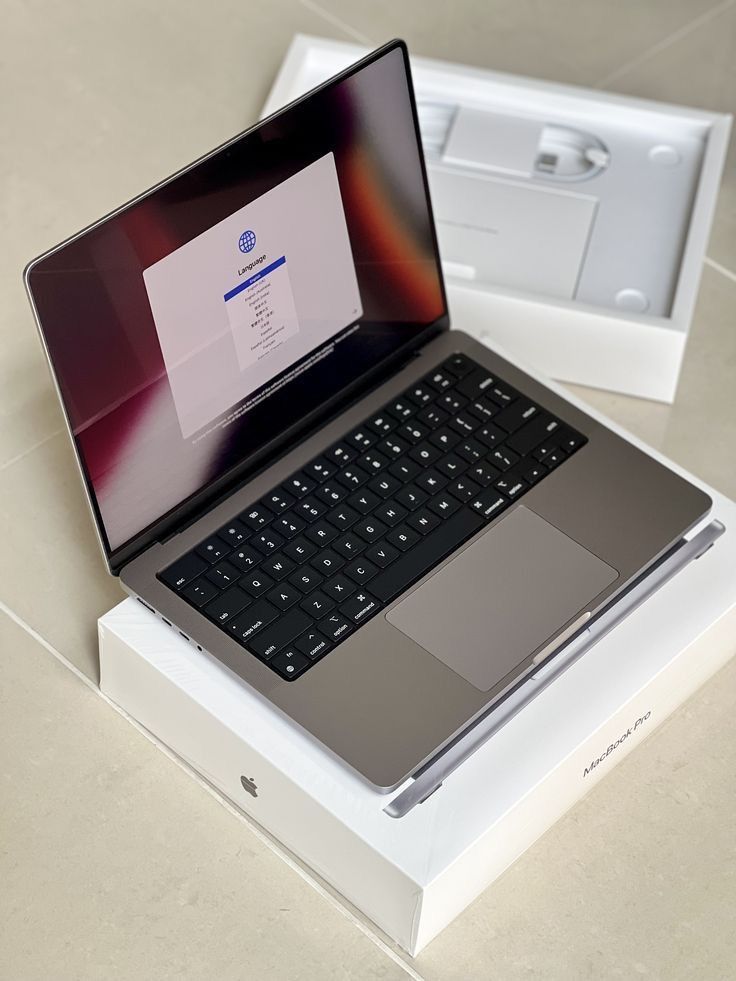 an open laptop computer sitting on top of a white box