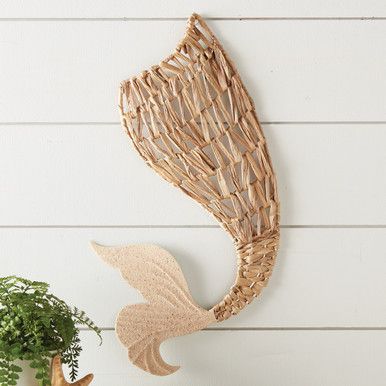 a wall hanging made out of wicker next to a potted plant on a shelf