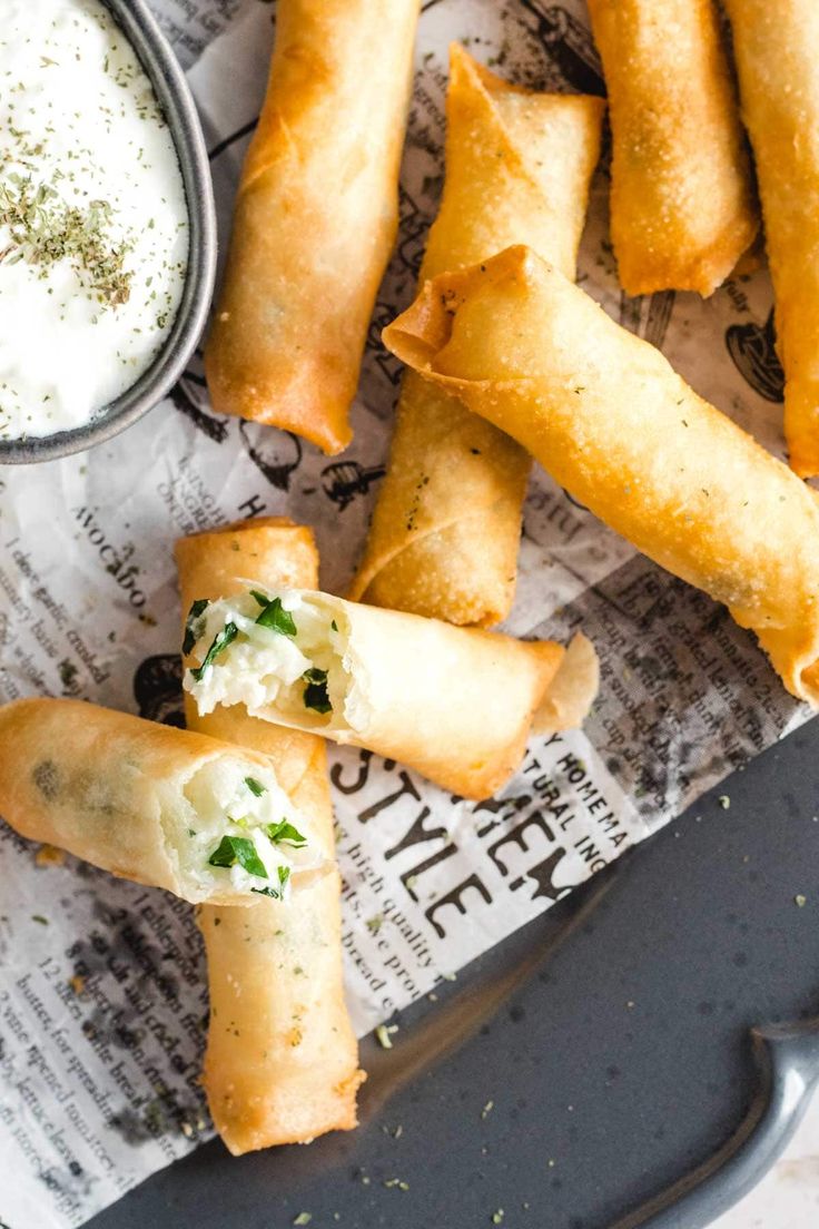 some appetizers are sitting on a tray next to a bowl of ranch dressing