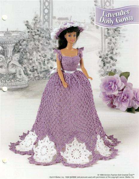 a crocheted doll in a purple dress and hat with white lace on it