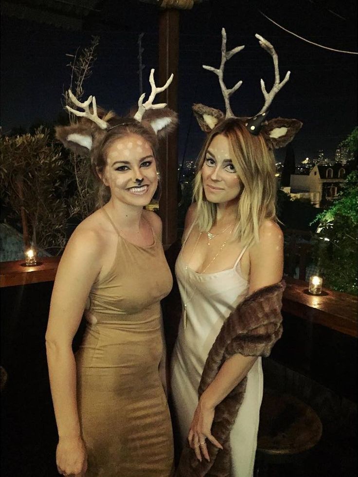 two women dressed up as deer with antlers on their head and one wearing a dress