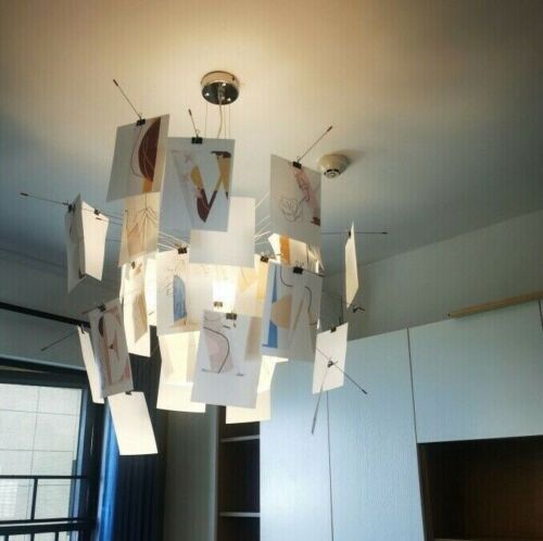 a chandelier hanging from the ceiling in a living room with pictures on it