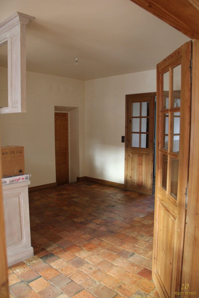 an empty room with wooden doors and brick floor