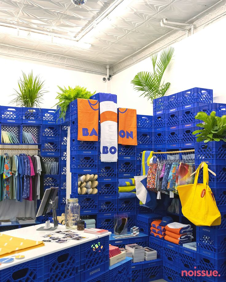 a blue rack filled with lots of items next to a white table and planters