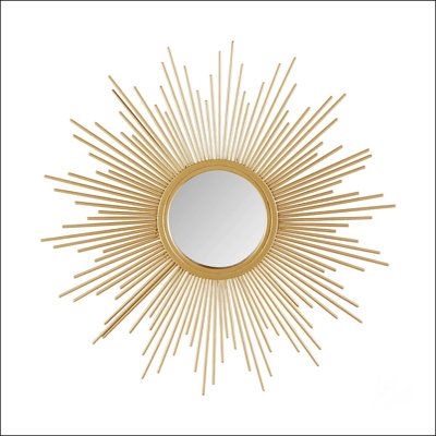 a gold sun mirror on a white wall