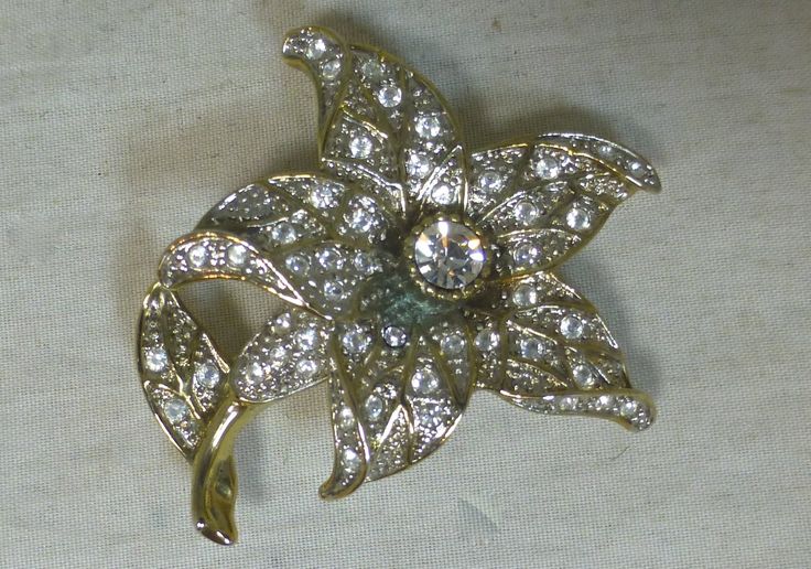 A beautiful Vintage Marcasite and Crystal Diamanté Flower Pin Brooch in Silver Tone Setting. The sparkling costume jewellery brooch is silver tone metal inlaid with marcasite and clear glass crystals. The brooch depicts a flower with leaf and stem and a single large crystal takes pride of place in the flower centre. The overall effect is a very pretty sparkly brooch. Made by a craftsman.  Very striking - no one else would have one like this. The brooch has secure roll over locking safety clasp c Flower Shaped Costume Jewelry Brooches For Wedding, Ornate Flower Brooch For Wedding, Ornate Flower Brooches For Wedding, Ornate Flower Shaped Wedding Brooches, Ornate Flower Brooches For Formal Occasions, Flower Shaped Costume Jewelry Brooch, Large Crystal, Flower Center, Floral Fashion